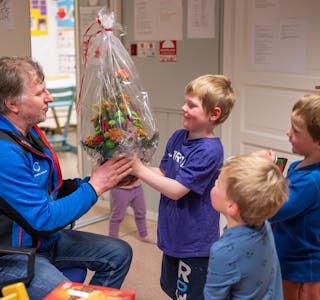 Marius Kvitnes Oksfjellelv gir blomster til Arnt Ingar.
